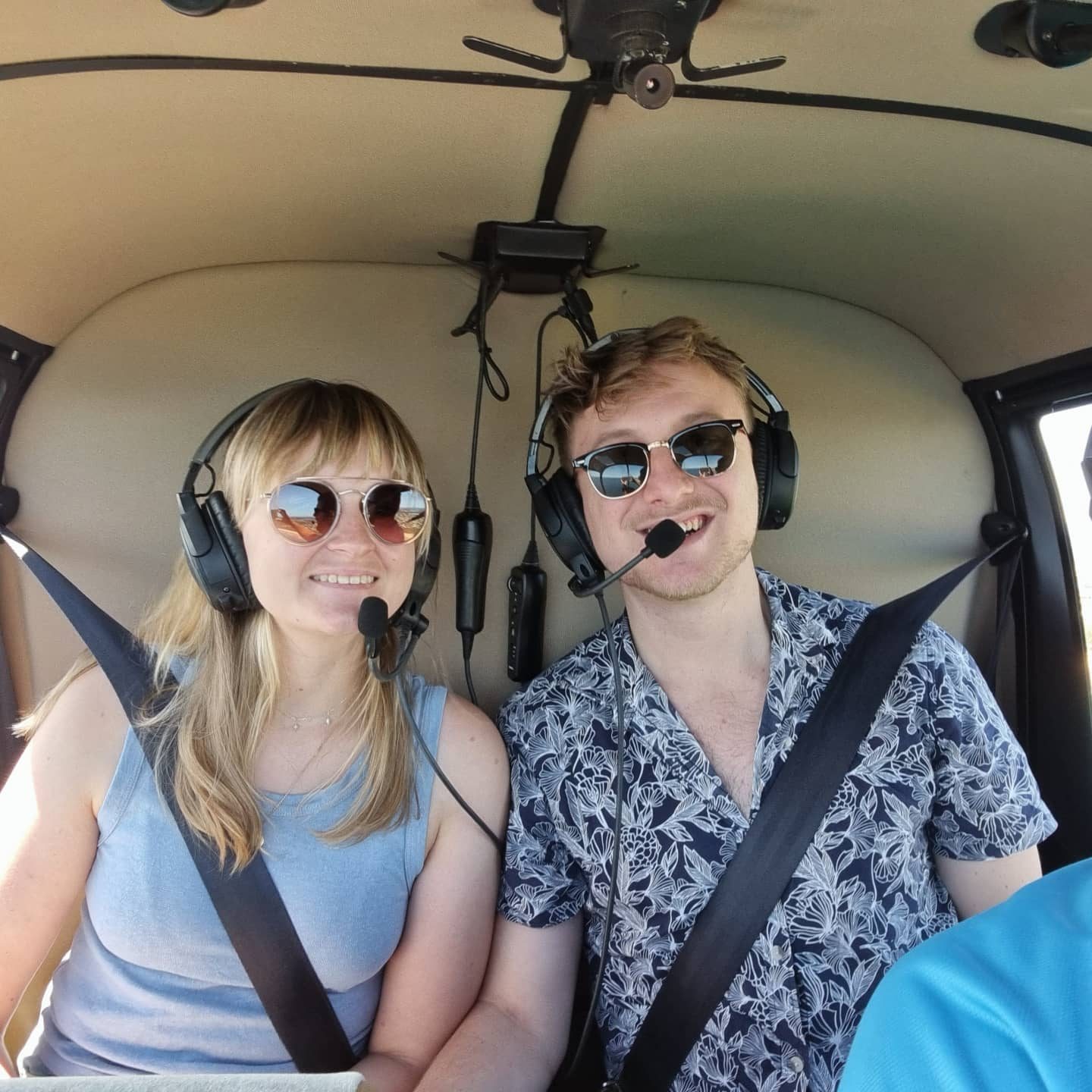 Maggie and Jack in a helicopter wearing headsets