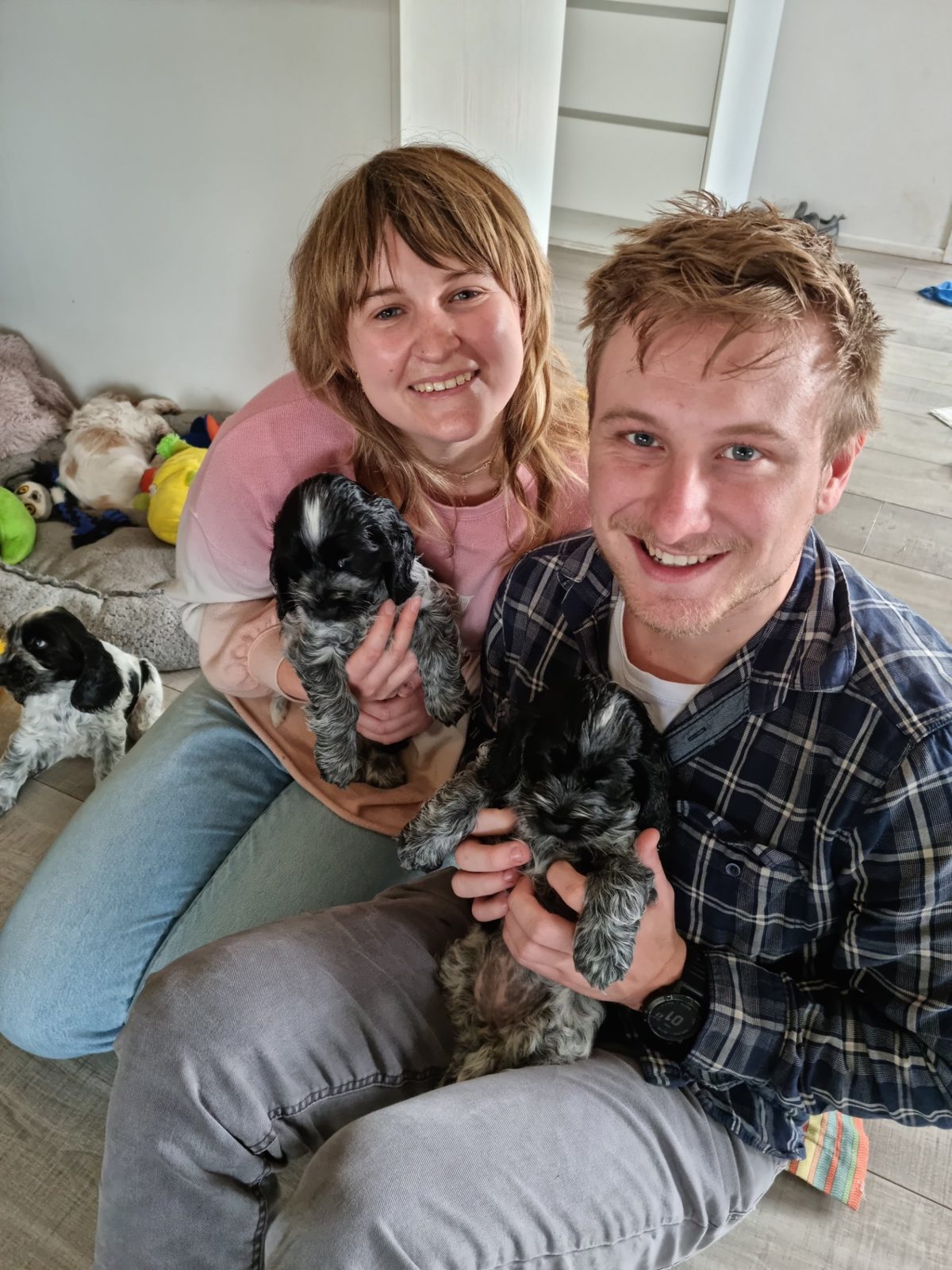 Maggie and Jack holding two cocker spaniel puppies